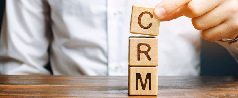 Diferenças entre CRM e ERP: gestor empilha blocos com as letras C, R e M