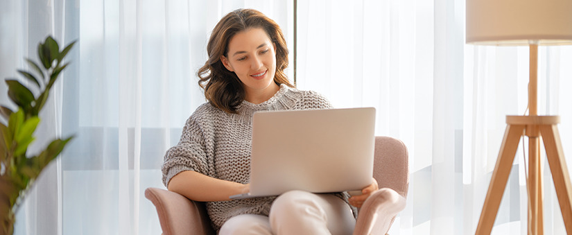 Plataformas no mercado imobiliário: mulher sorridente utiliza laptop