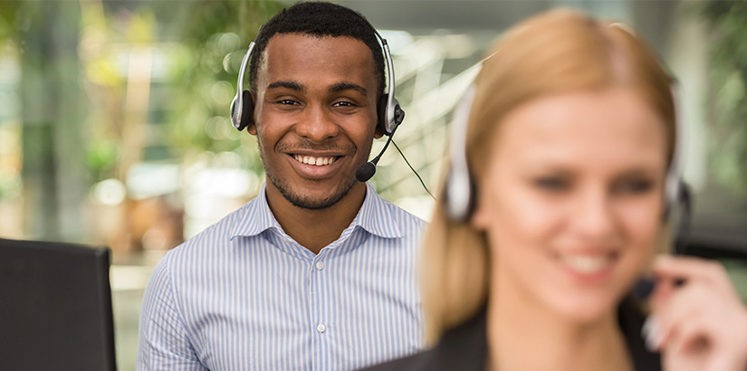 Suporte ao cliente: atendente olha para a câmera e sorri utilizando headset