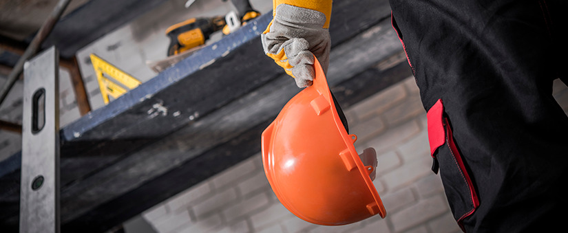 Construtor segurando capacete de obras