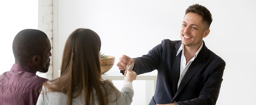 Taxas e impostos: imagem de homem entregando uma chave a um homem e uma mulher.