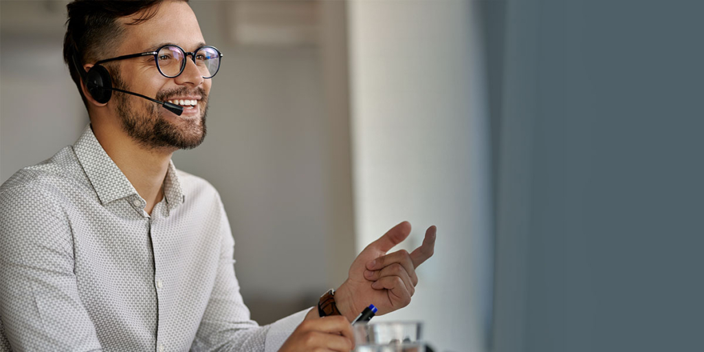 captar leads: imagem de um homem falando num microfone de fone e sorrindo.