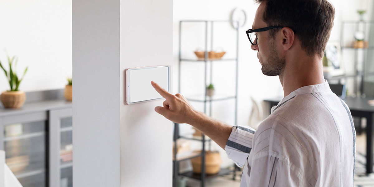 portaria virtual: imagem de um homem clicando na tela de um tablet colado na parede.