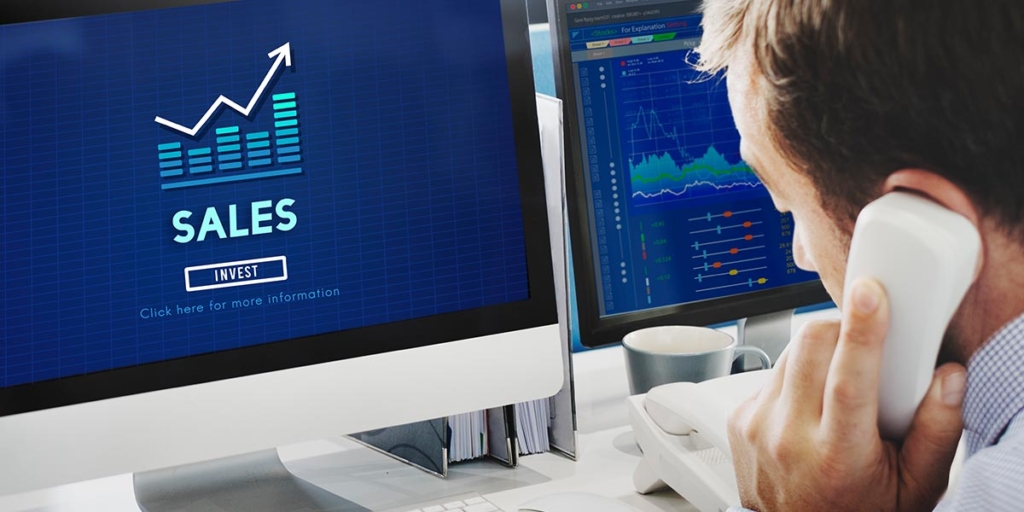 Oferta ativa: imagem de um homem de costas, segurando um telefone próximo ao ouvido. À sua frente um computador com o termo "Sales invest" escrito na tela.