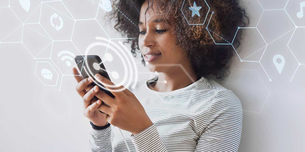 social mídia imobiliário: mulher encostada numa parede, segurando um celular.