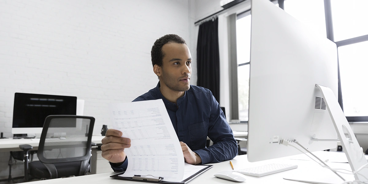 Gestor Imobiliário: imagem de um homem sentado à frente de uma mesa, num escritório. Na sua frebte um computador.