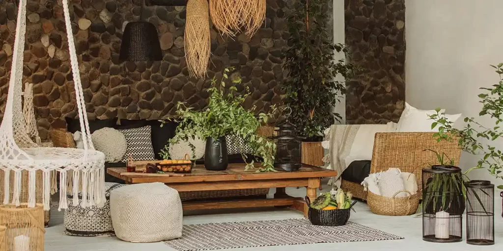 Móveis ecológicos: imagem de uma sala ampla, com muitas plantas, parede de troncos de madeira e móveis rústicos.