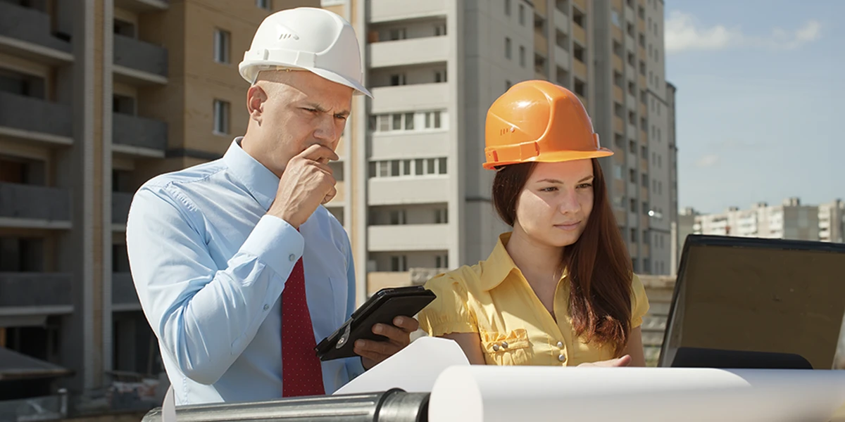 Negócios lucrativos na construção civil: imagem de duas pessoas usando capacetes num canteiro de obras.