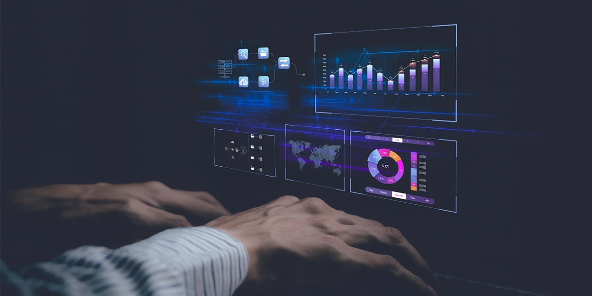 Software de Gerenciamento: close nas mãos de uma pessoa digitando num computador. A imagem é escura e, em destaque, alguns gráficos em destaque na tela.