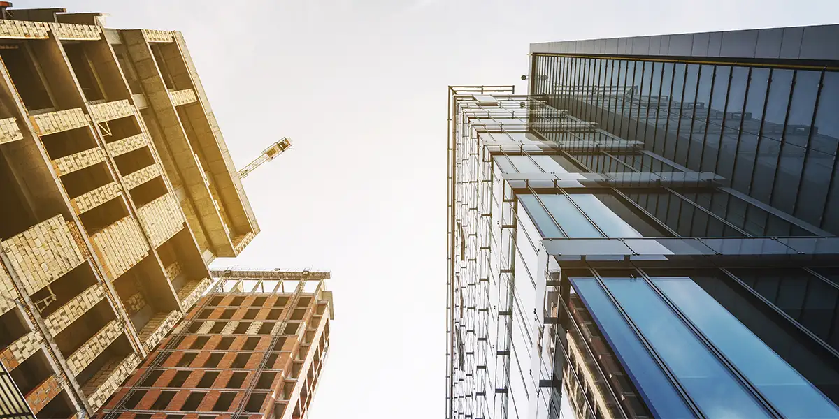 grandes construtoras: imagem vista de baixo para cima de prédios altos.