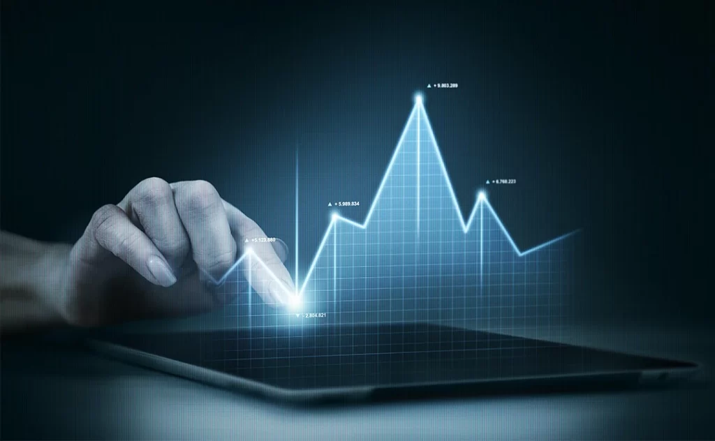  vantagens da inteligência artificial: imagem de uma mão apontando para um tablet numa mesa. Acima da tela sai um gráfico de linha.