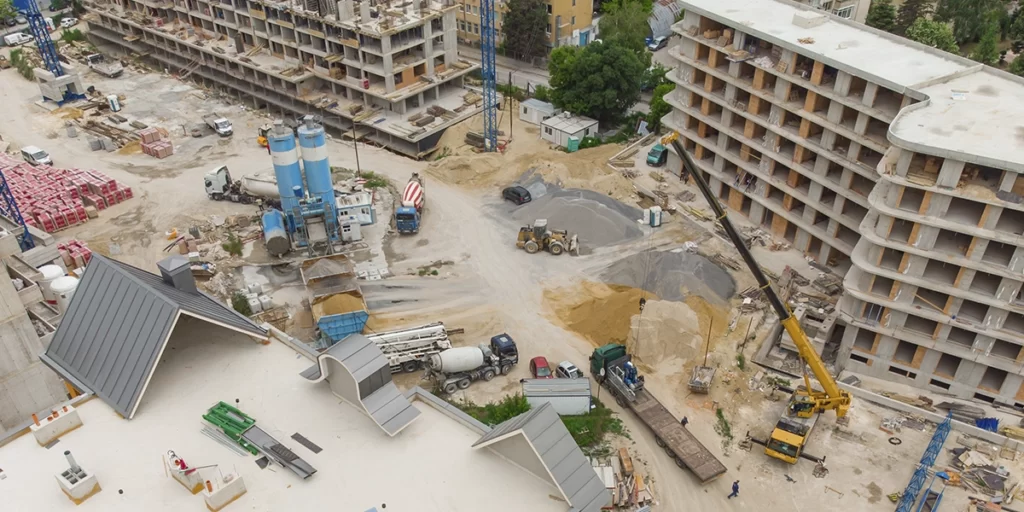 checklist de obra: A imagem mostra um complexo de construção em andamento. Há vários equipamentos de construção, como moinhos de cimento, caminhões de cimento, carregadores, e outros veículos de transporte e movimentação de material. Há também uma estrutura de metal que parece ser um craneo, que é comumente usado para transportar grandes quantidades de material ou para a manutenção de edifícios em construção.

O terreno é um pouco deserto, com grama e algumas árvores, e há uma estrutura que parece ser um edifício em construção, com várias andanadas visíveis. Há também uma área que parece ser um depósito de material, com grama e grama.

A imagem é um drone, o que significa que foi tirada de cima, o que permite uma visão geral do site de construção. A imagem é de baixa resolução, o que limita a capacidade de ver detalhes específicos.